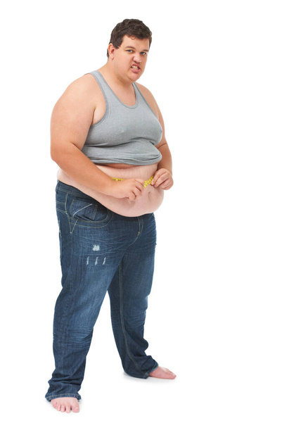 Obesity, tape measure on abdomen and portrait of angry man checking size, body health and isolated on white background. Frustrated male, measuring stomach and weight loss progress on studio backdrop - Fotó, kép