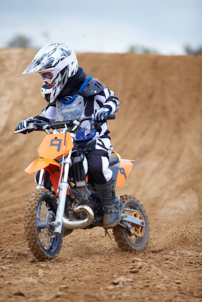 Motorcycle, sports and a child rider on a dirt track for racing, adventure or adrenaline outdoor during a hobby. Fitness, children and freedom with a boy kid on a bike for speed training or challenge. - Foto, Imagem