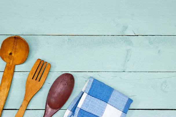 Cucchiaio e forchetta in legno, tovagliolo sul tavolo blu - Foto, immagini