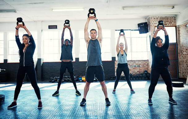 Daj szansę dynamice grupy. grupa fitness korzystająca z dzwonków-czajników podczas sesji na siłowni - Zdjęcie, obraz