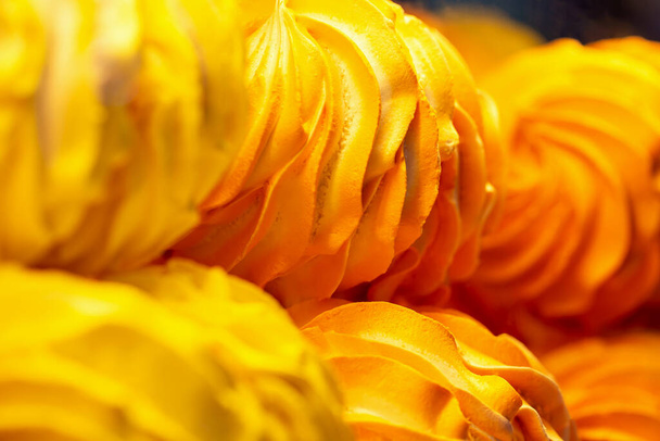 Fresh delicious yellow meringue close-up. Sweet Dreams. Orange background. Selective focus, defocus - Foto, afbeelding