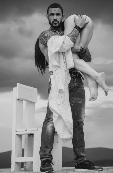 Latino handsome man and sexy woman. Man is carrying his woman. Love. Couple - Foto, afbeelding
