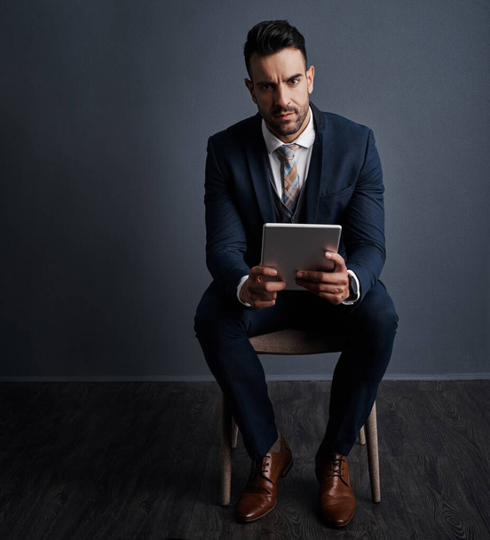 These apps keep me organized throughout the workday. Studio shot of a stylish young businessman using a digital tablet against a gray background - Fotoğraf, Görsel