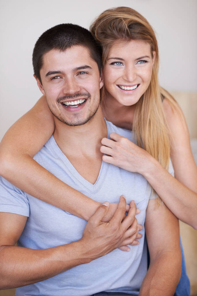 In love and feeling great. Attractive young couple relaxing together happily at home - Fotó, kép
