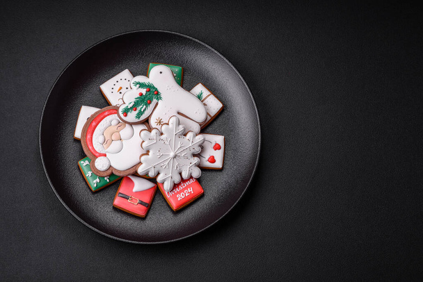 Köstliche frische bunte Weihnachts- oder Neujahrskekse auf einem Keramikteller auf dunklem Betongrund - Foto, Bild