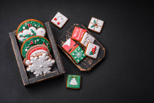 Delicious fresh colorful Christmas or New Year gingerbread cookies on a ceramic plate on a dark concrete background - Fotó, kép