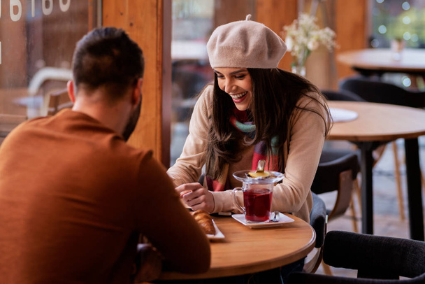 Beautiful woman and handsome man sitting together at a table in a cafe - Foto, Imagem