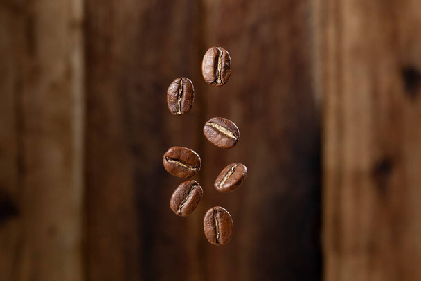 Roasted coffee beans from Colombia suspended in the air, Arabica variety. - Photo, Image
