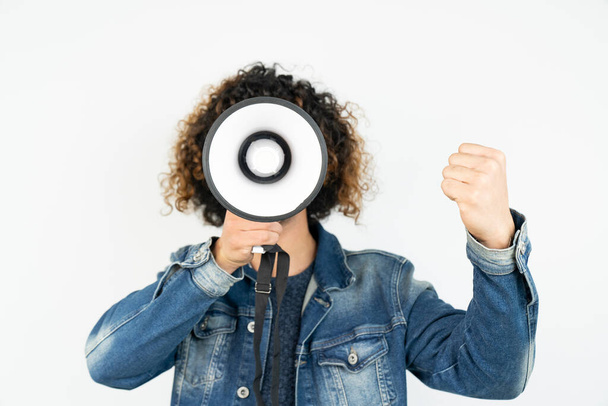 jonge man met een megafoon terwijl poseren tegen een witte achtergrond - Foto, afbeelding