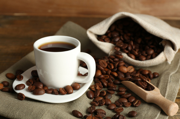 Šálek kávy s fazolemi na rustikální dřevěné pozadí - Fotografie, Obrázek