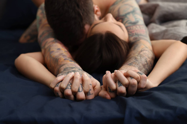 Passionate couple having sex on bed, focus on hands - Foto, Imagen