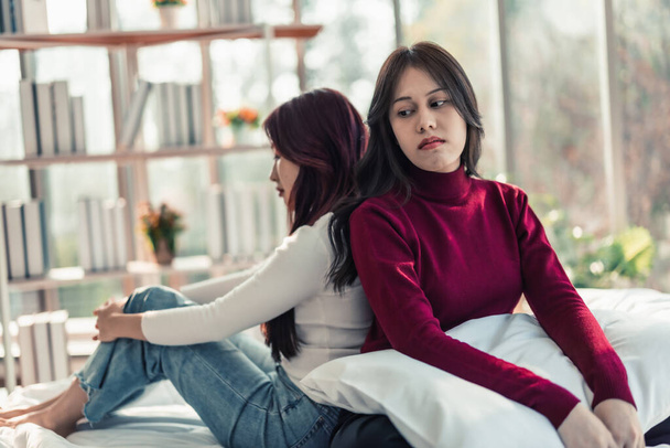 A Lesbian is annoyed, frustrated because her partner ignores and doesn't pay attention to her. Couples' conflicts make atmosphere tense and stressed. Misunderstanding can destroys relationships. - Foto, Bild