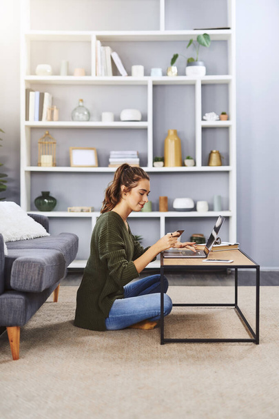 Refine your perfect shopping experience. Full length shot of a young woman using a laptop and credit card to do some online shopping at home - Valokuva, kuva