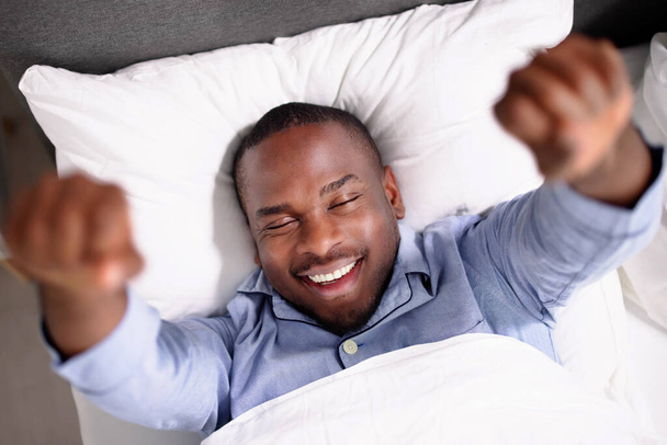 Young Happy Smiling African Man Waking Up At Bedroom - Fotó, kép