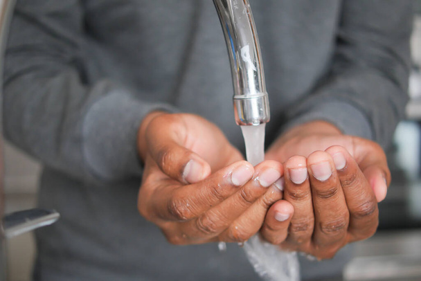 mladý muž mytí rukou s mýdlem teplou vodou. - Fotografie, Obrázek