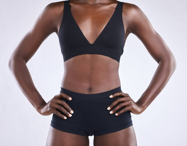Body, fitness and health with stomach of black woman in studio for nutrition, weight loss or diet. Lingerie, wellness and workout with tummy of female model on white background for self care and glow. - Photo, image