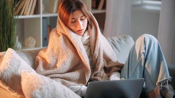 Sick job. Ill freelancer. Tired flu woman remote work on laptop feeling unwell high temperature influenza answering emails sitting on sofa in living room home interior. - Foto, Imagen