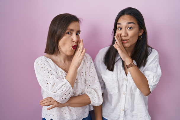 Hispanic mother and daughter together hand on mouth telling secret rumor, whispering malicious talk conversation  - Photo, Image