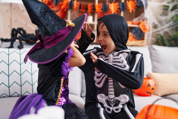 Imádnivaló fiú és lány halloween party csinál félelem gesztus otthon - Fotó, kép