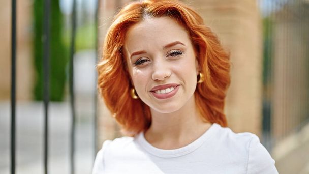 Young redhead woman smiling confident standing at street - Foto, afbeelding