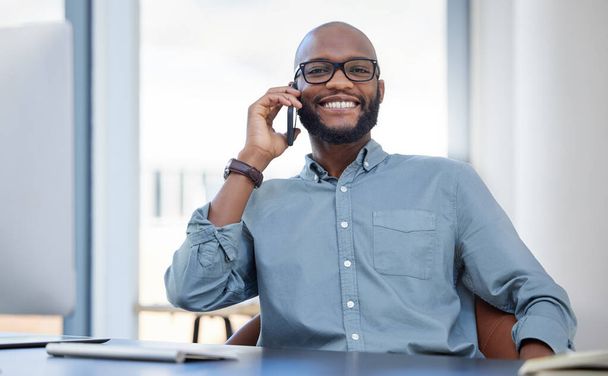 Χαμόγελο, πορτραίτο επιχειρηματία με κινητό και ένα τηλεφώνημα στο γραφείο του στο χώρο εργασίας. Online επικοινωνία, χαρούμενος και αφρικανός με smartphone μιλώντας στο σύγχρονο χώρο εργασίας του στο γραφείο. - Φωτογραφία, εικόνα