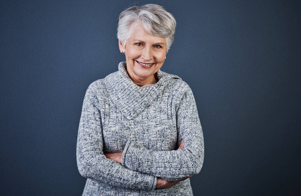 Le vieillissement est un processus merveilleux. Photo studio d'une femme âgée joyeuse debout les bras croisés en regardant la caméra - Photo, image