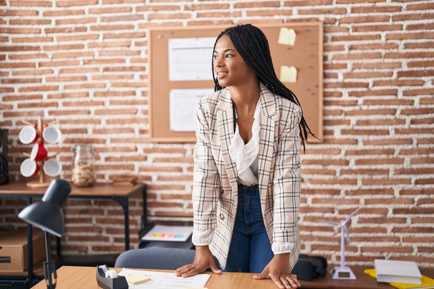 Αφρο-αμερικανίδα επιχειρηματίας χαμογελώντας αυτοπεποίθηση στέκεται στο γραφείο - Φωτογραφία, εικόνα