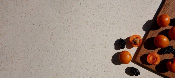 Close up de frutas frescas e saudáveis de verão, damascos e amora-preta sob sombras duras. Hora de Verão. Espaço para cópia. Banner extra largo. - Foto, Imagem