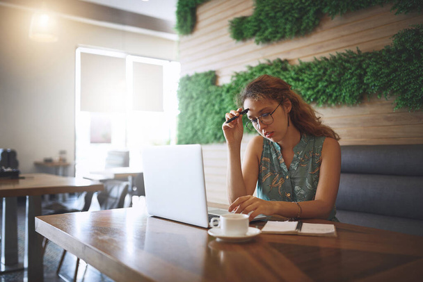 Trabajar independientemente no está funcionando. una mujer joven que usa una computadora portátil y se ve estresada mientras trabaja en un café - Foto, Imagen