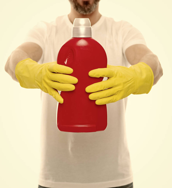 closeup of man with laundry detergent in studio. man with laundry detergent on background. photo of man with laundry detergent bottle. man with laundry detergent isolated on white. - Fotó, kép