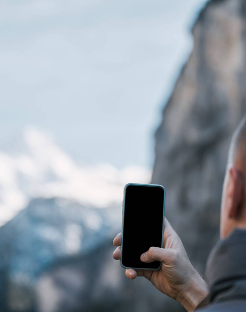 Man taking photos in beautiful outdoors. Traveling in Alps. Camera mockup - Zdjęcie, obraz