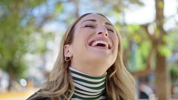 Νεαρή όμορφη Ισπανίδα γυναίκα χαμογελά με αυτοπεποίθηση στο πάρκο - Πλάνα, βίντεο