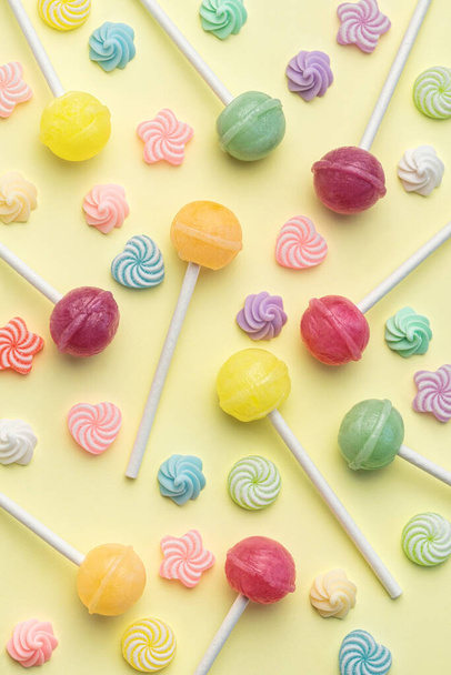 Colorful sweet lollipops and candies over yellow background.  Flat lay, top view - Valokuva, kuva