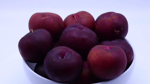 Fresh plums in a bowl isolated on white background - Footage, Video