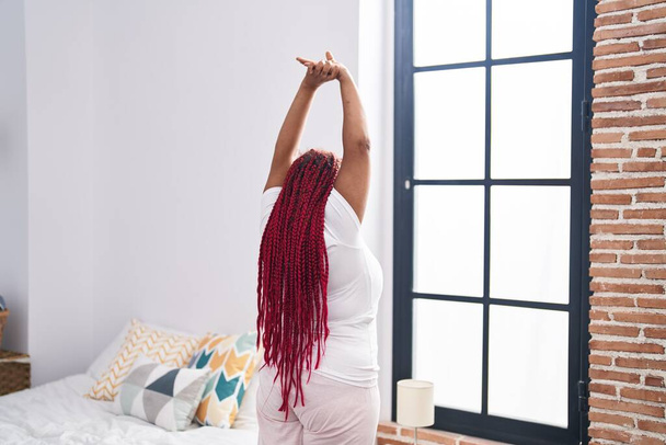 afro americano donna svegliarsi stretching braccia a camera da letto - Foto, immagini