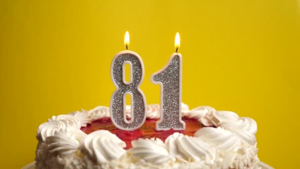 Una vela en la forma del número 81, atascada en un pastel de vacaciones, se apaga. Celebrar un cumpleaños o un evento histórico. El clímax de la celebración. - Metraje, vídeo