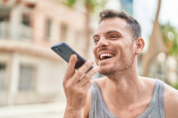 Young hispanic man smiling confident talking on the smartphone at street - Zdjęcie, obraz