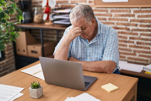 Homem de cabelos grisalhos de meia idade trabalhador de negócios estressado usando laptop no escritório - Foto, Imagem