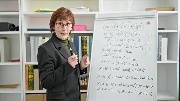 Dojrzała latynoska nauczycielka uczy matematyki na uniwersytecie w bibliotece - Zdjęcie, obraz