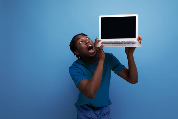 americano jovem masculino morena consultor em casual t-shirt mostra um laptop para publicidade. - Foto, Imagem