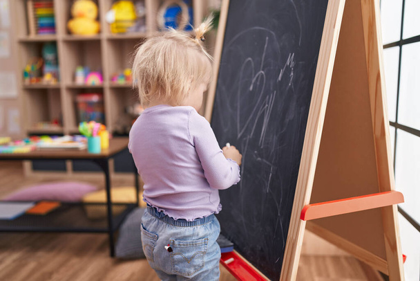 Adorable chica rubia preescolar dibujo en pizarra en el jardín de infantes - Foto, imagen
