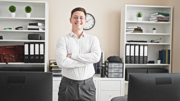 Young hispanic man business worker smiling confident standing with arms crossed gesture at office - Photo, Image
