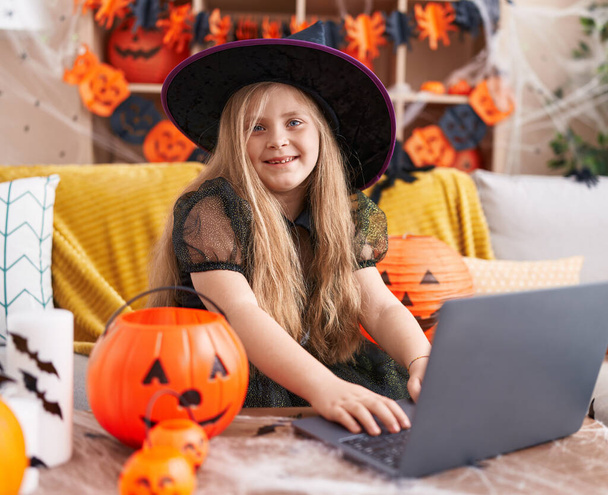 Чарівна блондинка в костюмі відьми використовує ноутбук вдома - Фото, зображення