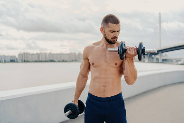 筋肉の男は、トレーニングの筋肉の屋外で、フィットネスのために動機を無気力に行使する。スポーツ、ボディービルの概念. - 写真・画像