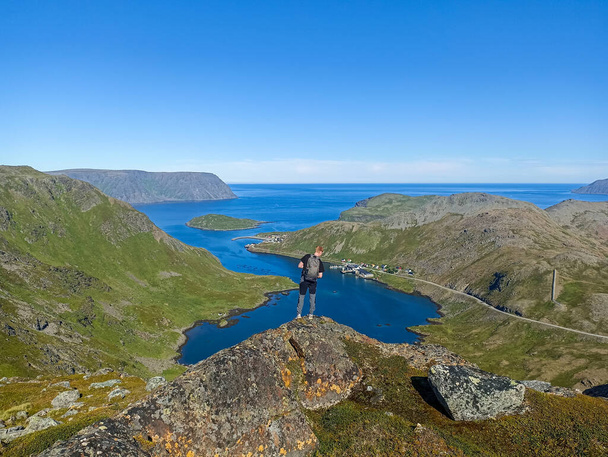 Un voyageur profitant du paysage de Risfjorden et de la nature de l'île de Mageroya, Finnmark, Norvège - Photo, image
