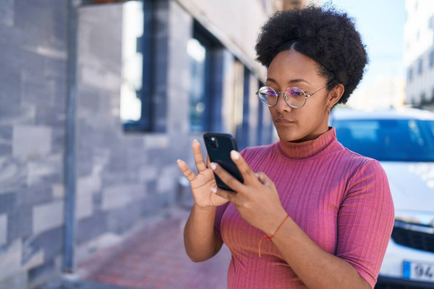 Afrikai amerikai nő használ okostelefon komoly kifejezés az utcán - Fotó, kép