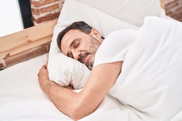 Hombre de mediana edad acostado en la cama durmiendo en el dormitorio - Foto, imagen