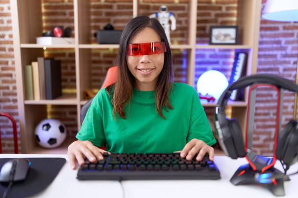 Chińska kobieta w średnim wieku w okularach wirtualnej rzeczywistości z uśmiechem na twarzy. szczęśliwy człowiek.  - Zdjęcie, obraz