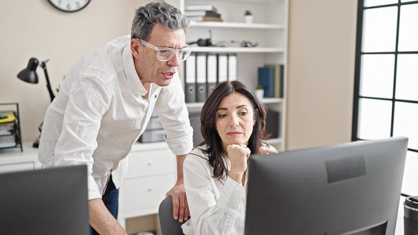 Senior man and woman business workers using computer speaking at office - Photo, Image