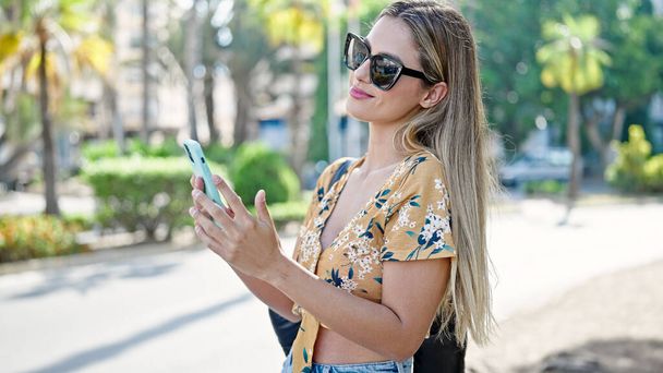 Young blonde woman smiling confident using smartphone at street - Foto, Bild